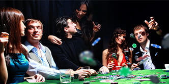 Casinobesucher, die an einem Tisch Karten spielen.